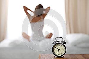 Woman stretching in bed after wake up, back view, entering a day happy and relaxed after good night sleep. Sweet dreams