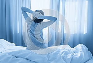 Woman stretching in bed after wake up, with copy space