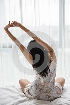 woman stretching in bed, wake up morning