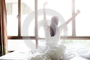Woman stretching in bed after wake up. photo