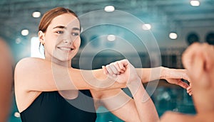 Woman stretching, fitness and swimmer arm, athlete start training at swimming pool for sports with smile. Exercise