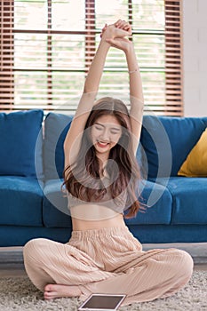 Woman stretching her body because feel tired after waching tablet, Lifestyle woman relax at home concept