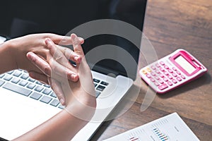 Woman is stretching at her hand office desk