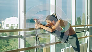 Woman stretching her leg at the barre