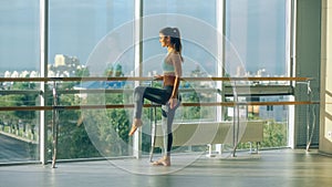 Woman stretching her leg at the barre