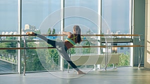 Woman stretching her leg at the barre