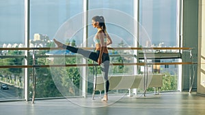 Woman stretching her leg at the barre