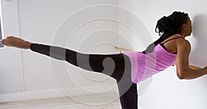 Woman stretching her leg at barre in fitness studio 4k