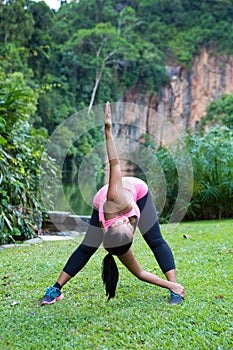 woman stretching her lower back muscle by bending forward and twisting to one side