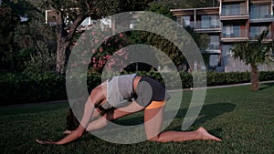 Woman stretching leg muscles on ground in evening outdoors