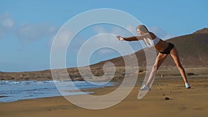 Woman stretching legs and hamstrings doing Standing Forward Bend Yoga stretch pose on beach. Fitness woman relaxing and