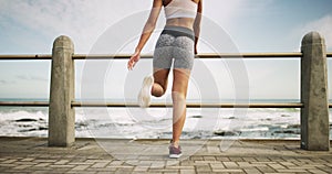 Woman, stretching legs and ocean promenade for warm up, training and healthy muscle to stop injury. Runner girl back