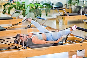 Woman stretching legs on pilates reformer photo