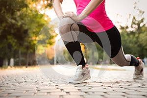 Woman stretching before morning run in park, closeup. Space for text