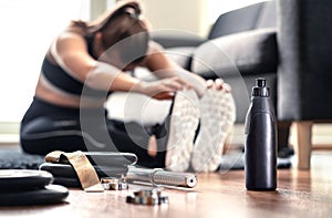 Woman stretching muscles before gym workout and weight training in home living room. Female fitness athlete doing warm up. photo