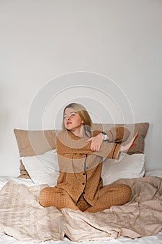 Woman stretching in pajamas with smartwatch