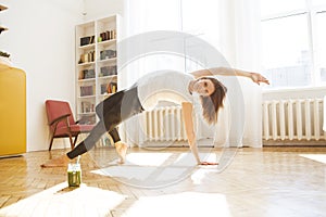 Woman stretching in room at home. Healthy and sport lifestyle. Fitness sport girl doing yoga fitness exercise.