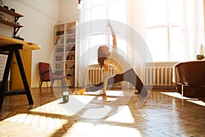 Woman stretching in room at home. Healthy and sport lifestyle. Fitness sport girl doing yoga fitness exercise.