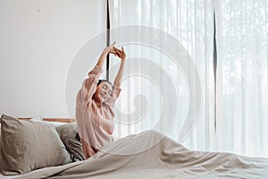 Woman stretching in a sunny bedroom