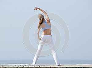 Woman stretching before workout at beach