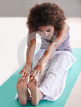 Woman, stretching and yoga for health and body on floor in studio with holistic wellness on the floor. Young and African