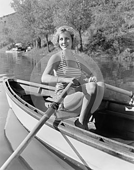 Woman in a striped bathing suit rowing