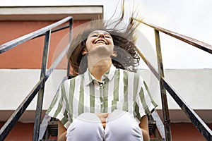 Woman in striped shirt waving her hair. Straight hair and madness concept.