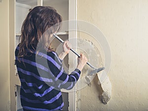 Woman stripping wallpaper