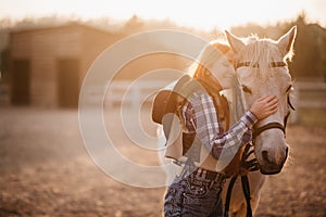 A woman stroking a horse at a ranch.