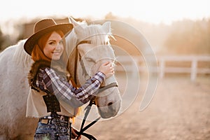 A woman stroking a horse at a ranch.