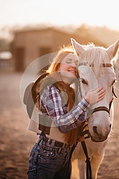 A woman stroking a horse at a ranch.