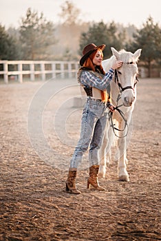 A woman stroking a horse at a ranch.