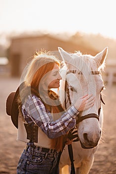 A woman stroking a horse at a ranch.