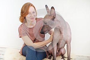 A woman stroking a Mexican Hairless Dog