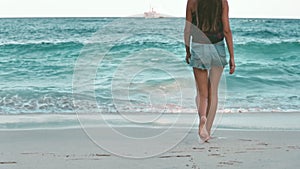 Woman strolling ocean sand beach slow motion.