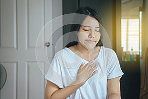Woman with strong chest pain and hands touching her chest,Heart attack symptom