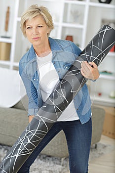Woman struggling to carry heavy roll material