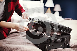 Woman struggling to close suitcase
