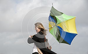 Woman struggling to hold her umbrella on a windy day