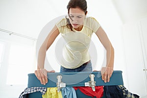 Woman struggling to shut suitcase