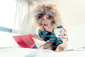 Woman student on her bed learning for exam in panic