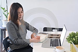 Woman student making notion notebook and studying online with laptop computer.