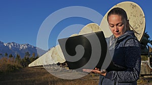 Woman student operator of institute of Solar Terrestrial Physics monitors communication equipment in notebook. Unique