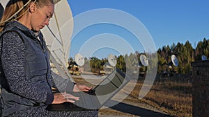 Woman student operator of institute of solar terrestrial physics monitors communication equipment in notebook. Unique