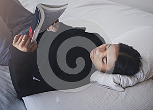 Woman, student and reading book in bedroom for relax, learning and studying at home. Young teenager, college girl and