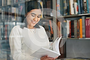 Woman, student and reading in college library with smile for research, learning and education. Happy, female person, and