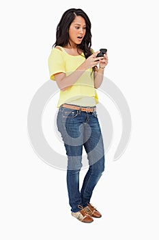 Woman student surprised while using a smartphone