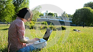 Woman student working on laptop computer in colledge campus