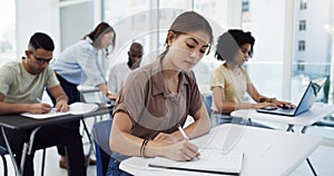 Woman, students and writing with test in classroom for exam, study or assignment at university. Female person or group