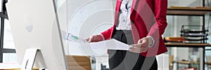 Woman studies investigation papers standing at table